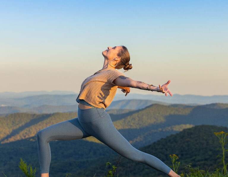 woman doing a yoga pose with mountain backdrop